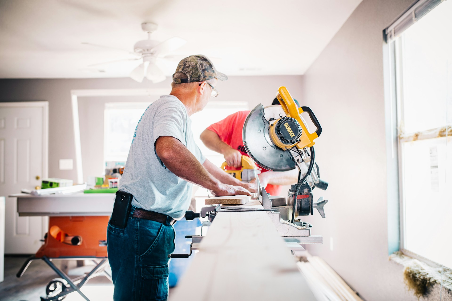 man cutting lumber in a house