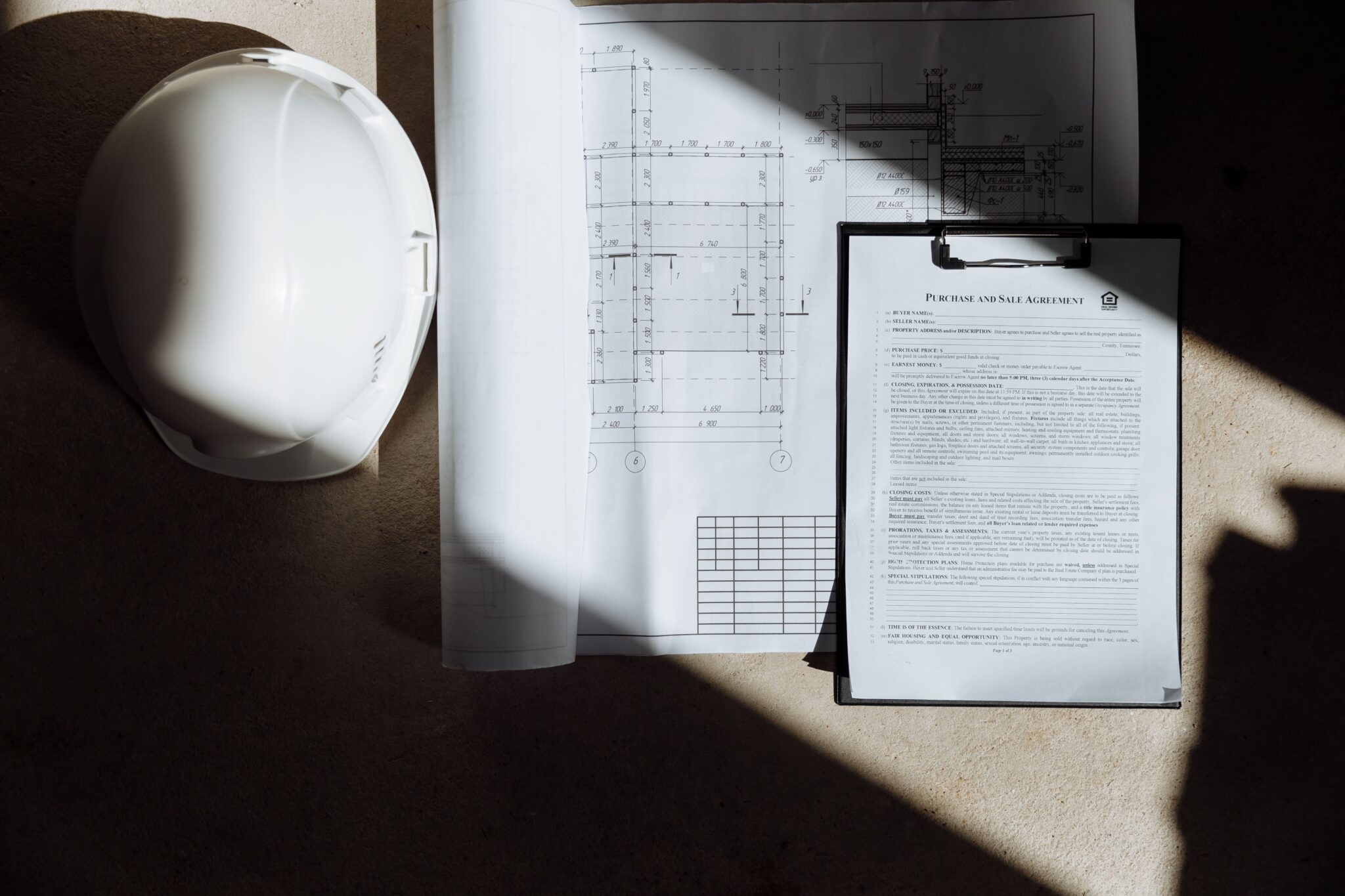 construction hat with papers in shadow